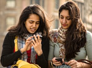 students sitting outside with phones