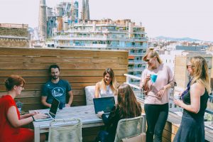people sitting with laptops on Barcelona rooftop