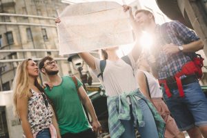 Happy traveling tourists sightseeing with map in hand