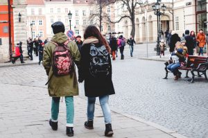 Two young people with backpacks walking in European city